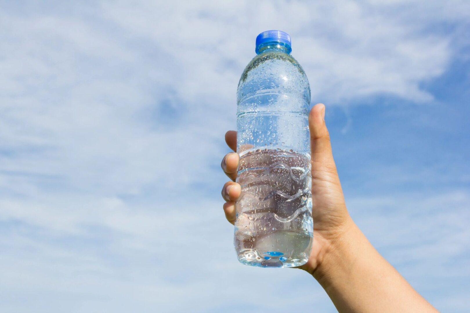 A person holding a water bottle in their hand.